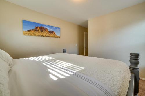 um quarto com uma cama branca e uma pintura na parede em Relaxing Phoenix Home with Patio and Fenced-In Yard em Phoenix