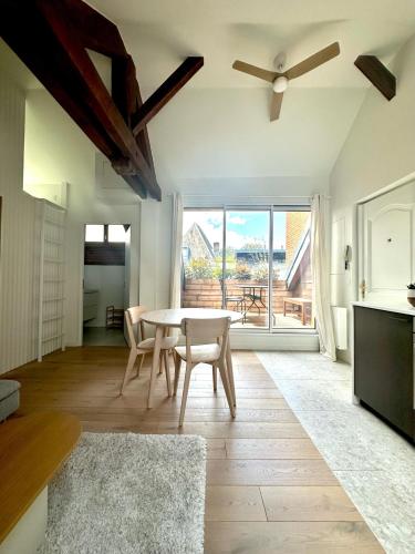 un salon avec une table et des chaises et une fenêtre dans l'établissement Écrin de calme avec terrasse, à Chambéry