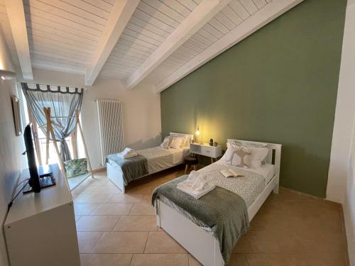 una camera con due letti e una tv di Patruno holidays house a Castellana Grotte