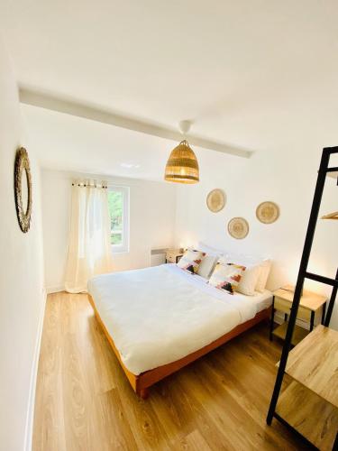 une chambre avec un grand lit blanc et du parquet dans l'établissement CasaJoy, MS, Aix-en-Provence, à Aix-en-Provence
