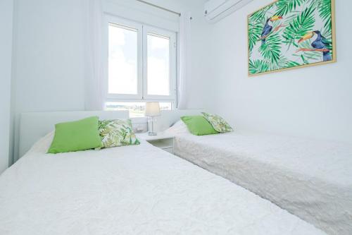two beds in a white room with green pillows at Samaniego ID175 in Orihuela Costa