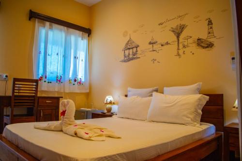 a bedroom with a bed with a stuffed animal on it at VILLA MIA in Nosy Be