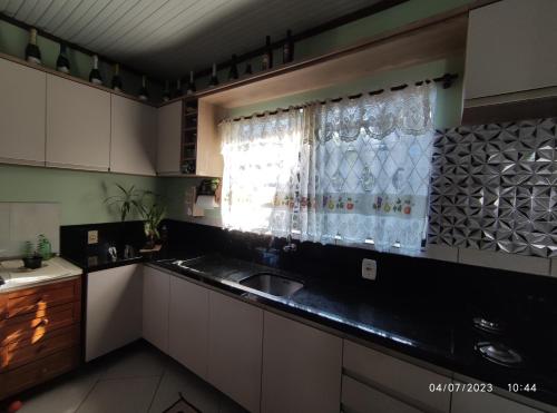 a kitchen with a sink and a window at Quarto, piscina e acesso exclusivo in Encantado