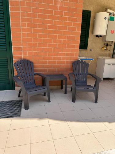 two chairs and a table in front of a brick wall at B&B af in Massafra
