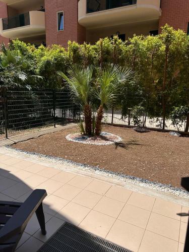 a garden with palm trees in front of a building at B&B af in Massafra