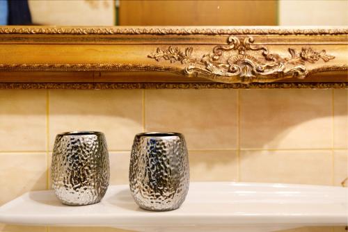 two silver vases sitting on a shelf in front of a mirror at Aschaubichl - Wohnung Enzian in Grainau