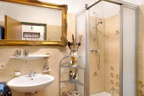 a bathroom with a sink and a shower with a mirror at Aschaubichl - Wohnung Enzian in Grainau