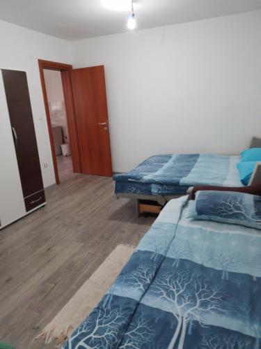 a bedroom with two beds and a wooden floor at Apartman Uros in Pale