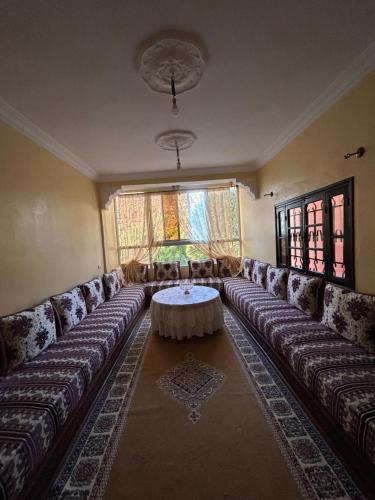 een woonkamer met een bank en een tafel bij Appartement avec belle vue à ourika Oulmes in Marrakesh