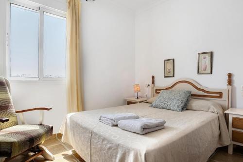 een slaapkamer met een bed met twee handdoeken erop bij Estudio Pacifico 201 in Conil de la Frontera