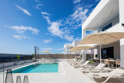 una piscina sul tetto di un edificio con sedie e ombrelloni di Babis Villa, a few meters away from the beach, By ThinkVilla a Panormos