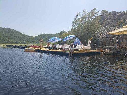 a group of people sitting on a dock in the water at Feel the Karuch in Cetinje