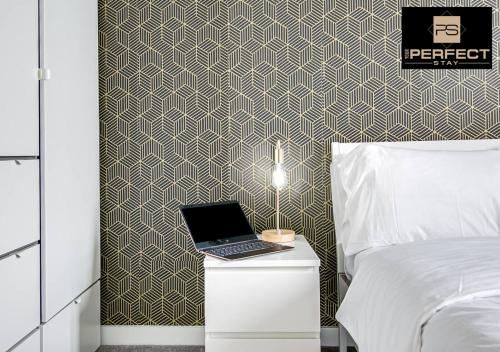 a bedroom with a bed and a laptop on a night stand at Manhattan Apartment City Centre By Your Perfect Stay short lets Birmingham in Birmingham