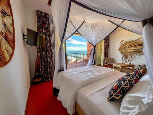 a bedroom with a bed with a view of the ocean at Maison Ylang Dive Center in Nosy Be