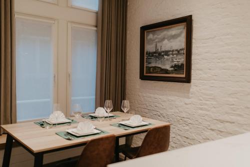 a table with wine glasses and napkins on it at Blue Bird Residence Wijngaard in Antwerp