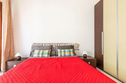 een slaapkamer met een rood bed met 2 kussens bij Casa Etruschi - Appartamento con posto auto in Livorno