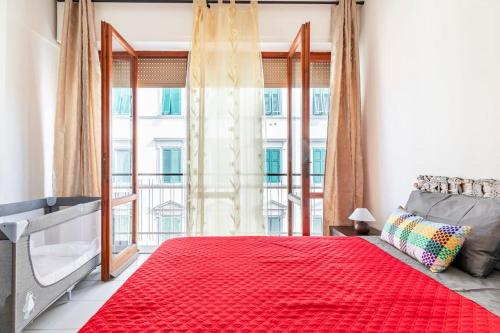 een slaapkamer met een rood bed en een groot raam bij Casa Etruschi - Appartamento con posto auto in Livorno