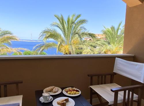 un tavolo con due piatti di cibo e una vista sull'oceano di Altafiumara Resort & Spa a Villa San Giovanni