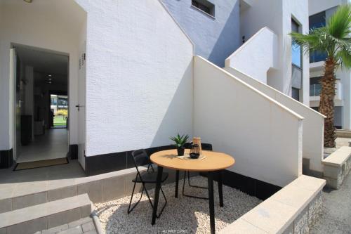 a small table sitting on the side of a building at Oasis Beach XII - Casa Lotus in Guardamar del Segura
