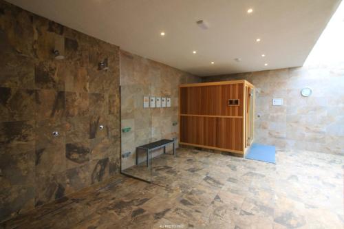 a bathroom with a shower and a wooden cabinet at Oasis Beach XII - Casa Lotus in Guardamar del Segura
