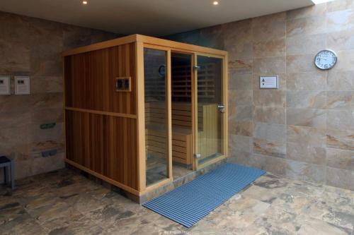 a wooden shower in a room with a clock on the wall at Oasis Beach XII - Casa Lotus in Guardamar del Segura