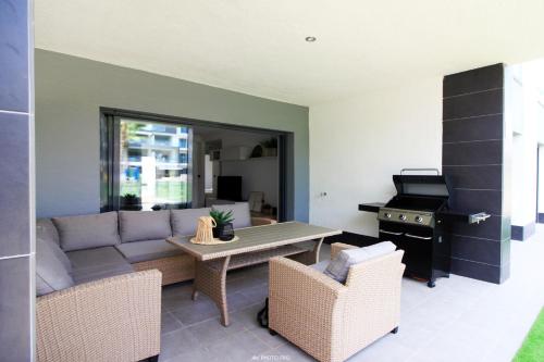 a living room with a couch and a table and a stove at Oasis Beach XII - Casa Lotus in Guardamar del Segura
