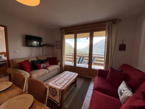 a living room with a couch and a table at Apartment l’Alpette Oz en Oisans in Oz