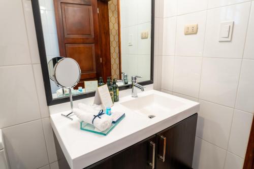 a bathroom with a white sink and a mirror at Hotel Boutique Santa Lucia in Cuenca