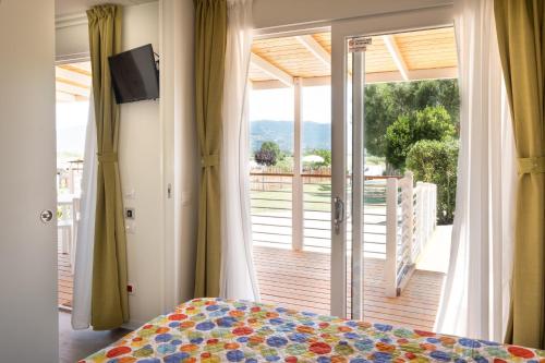 una camera con letto e porta scorrevole in vetro di Mobile home Margherita Agricamping Spineta a Cortona
