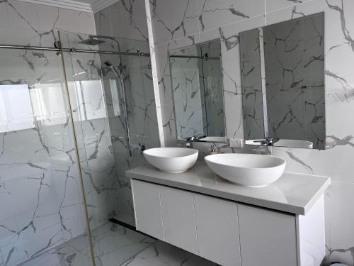 een badkamer met 2 wastafels en een spiegel bij A5U3 Hostel in Gold Coast