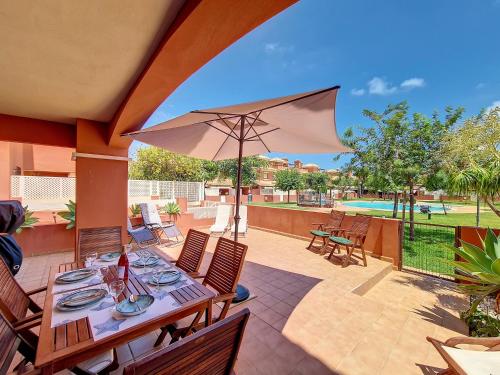 a patio with a table and an umbrella at Albatros Playa 1 - 9609 in Mar de Cristal
