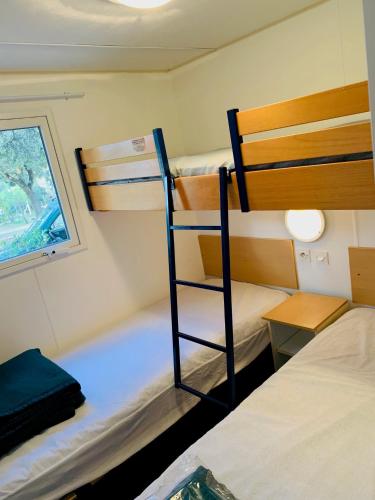 a room with two bunk beds and a window at Camping l'Horizon 30 in Les Mages