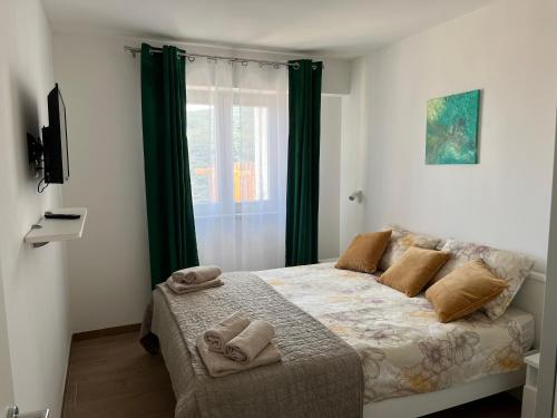 a bedroom with a bed with two towels on it at Apartments Zahtila - Berto in Rabac