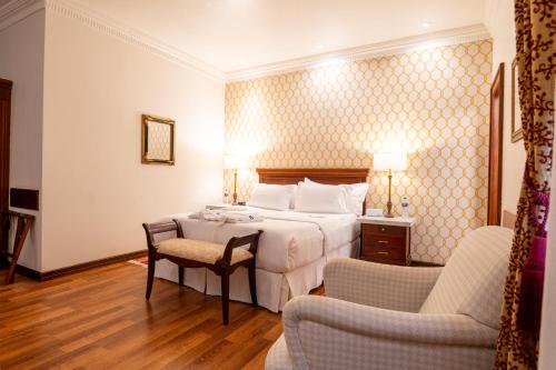 a hotel room with a bed and two chairs at Hotel Boutique Santa Lucia in Cuenca