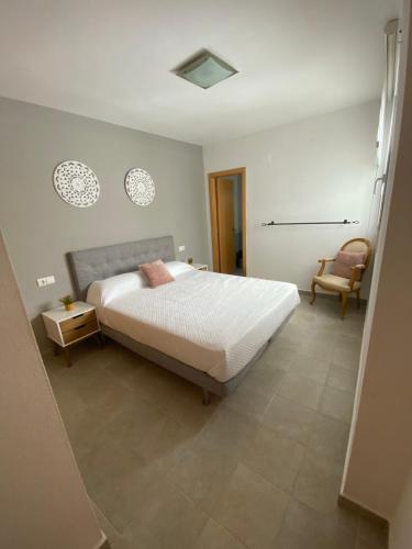 a bedroom with a large bed and a chair at Palangre Suite en Moraira in Moraira