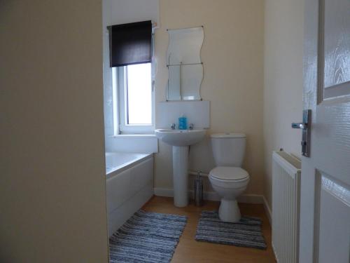 a bathroom with a toilet and a sink and a window at Middlecroft House in Staveley