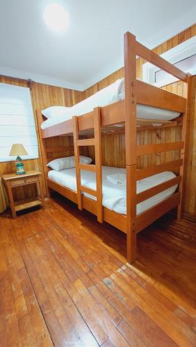 two bunk beds in a room with wooden floors at Hotel y Cabañas Llanuras de Diana - Caja Los Andes in Puerto Natales