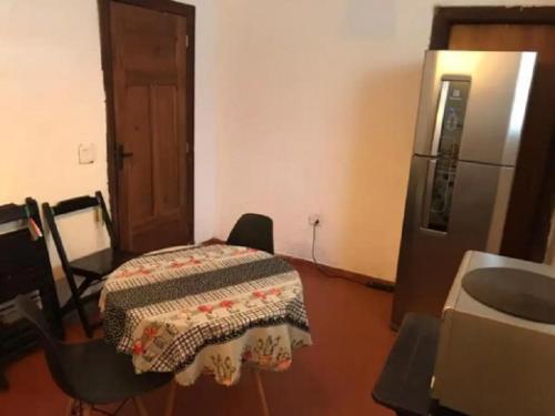 a kitchen with a table and a refrigerator at Quarto Zen in São Paulo