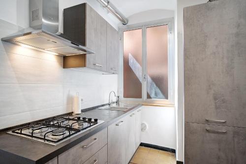 a kitchen with a stove top oven next to a window at Casa Acqua Mare Parasio in Imperia
