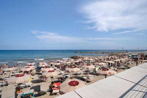 a beach with a lot of umbrellas and the ocean at Casa Acqua Mare Parasio in Imperia