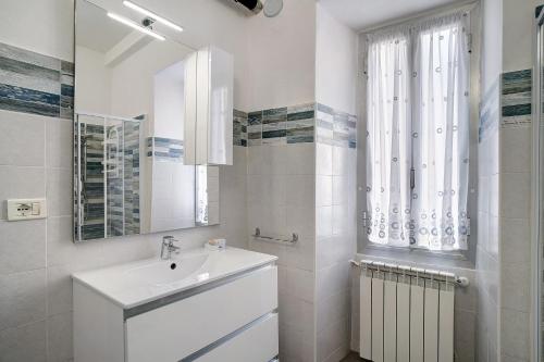 a white bathroom with a sink and a mirror at Casa Acqua Mare Parasio in Imperia