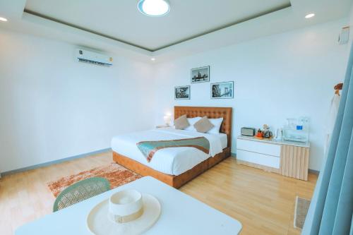 a bedroom with a bed and a table in a room at ไนท์สกาย โฮมสเตย์ in Ban Mae Na