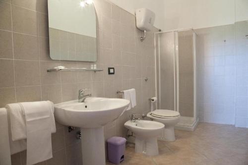 a bathroom with a sink and a toilet and a mirror at Residence Hotel Monte Ricciu in Alghero