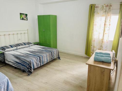 アリカンテにあるAlona Homeのベッドルーム1室(ベッド1台付)、緑のキャビネットが備わります。