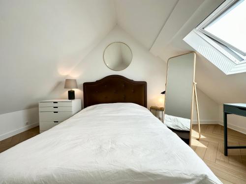 a white bedroom with a bed and a mirror at Lovely ! Duplex de standing neuf – 250m des plages in Larmor-Plage
