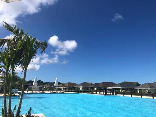 a large swimming pool with a palm tree and houses at Villa Exclusive in Richmond