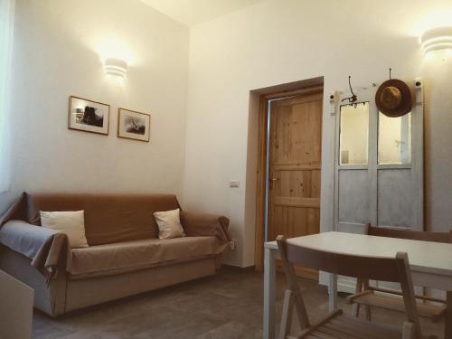 a living room with a couch and a table at Alloggio 2 / Casa Marley Porto Pollo in Barrabisa