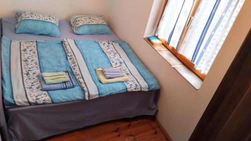 a bed with blue blankets and pillows in a bedroom at GuestHouse Zabljak in Žabljak
