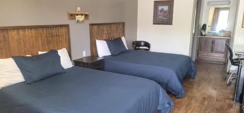 a hotel room with two beds with blue comforters at Blue Sky Inn- Complimentary Happy Hour Th-Sun, Veteran owned, Full Breakfast, Best green space, 1 mile from Blue Ridge, Fire Pit in Blue Ridge