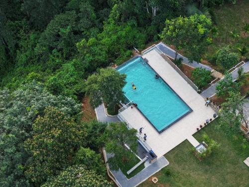 einen Ausblick über einen großen Pool mit Menschen um ihn herum in der Unterkunft Rivulet Resort in Munnar